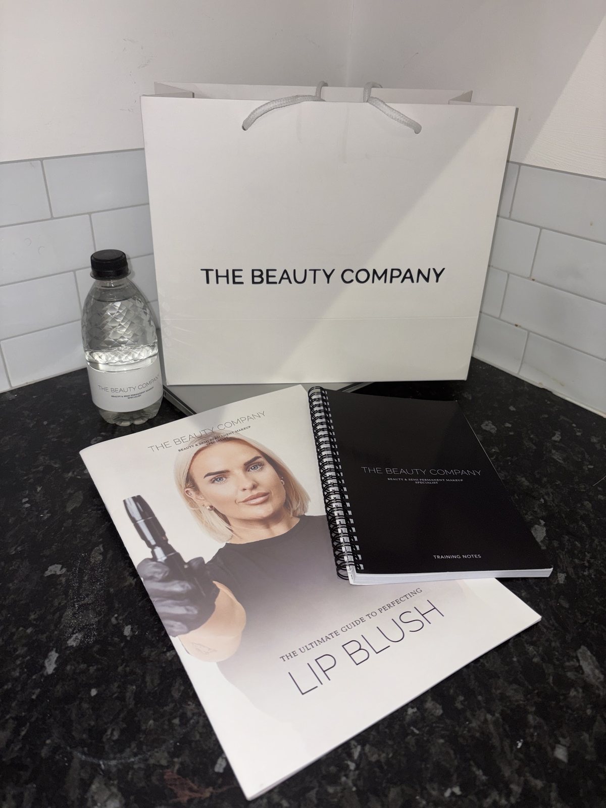 A Beauty Company bag beside Beth’s printed lip blush training manuals